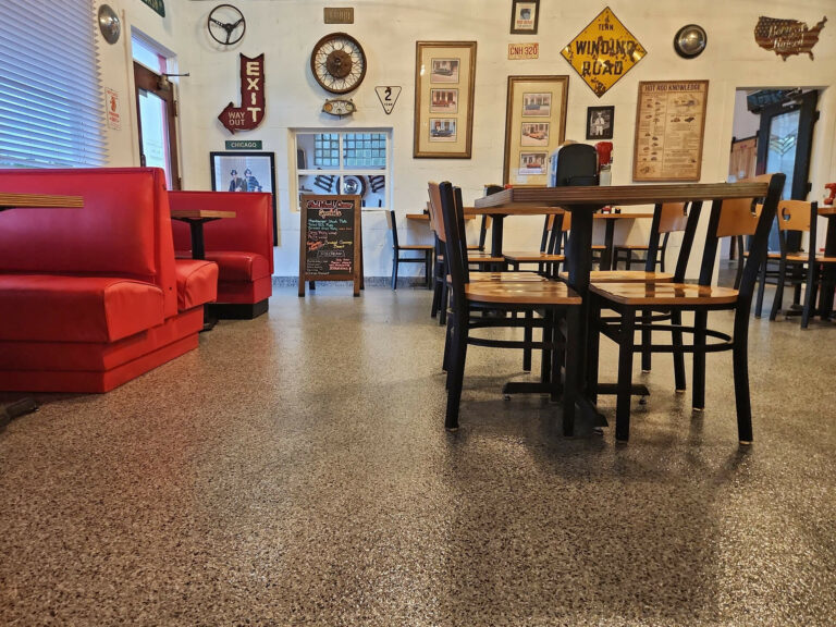Retro diner interior featuring red booths, wooden tables, vintage wall décor, and durable epoxy flake flooring