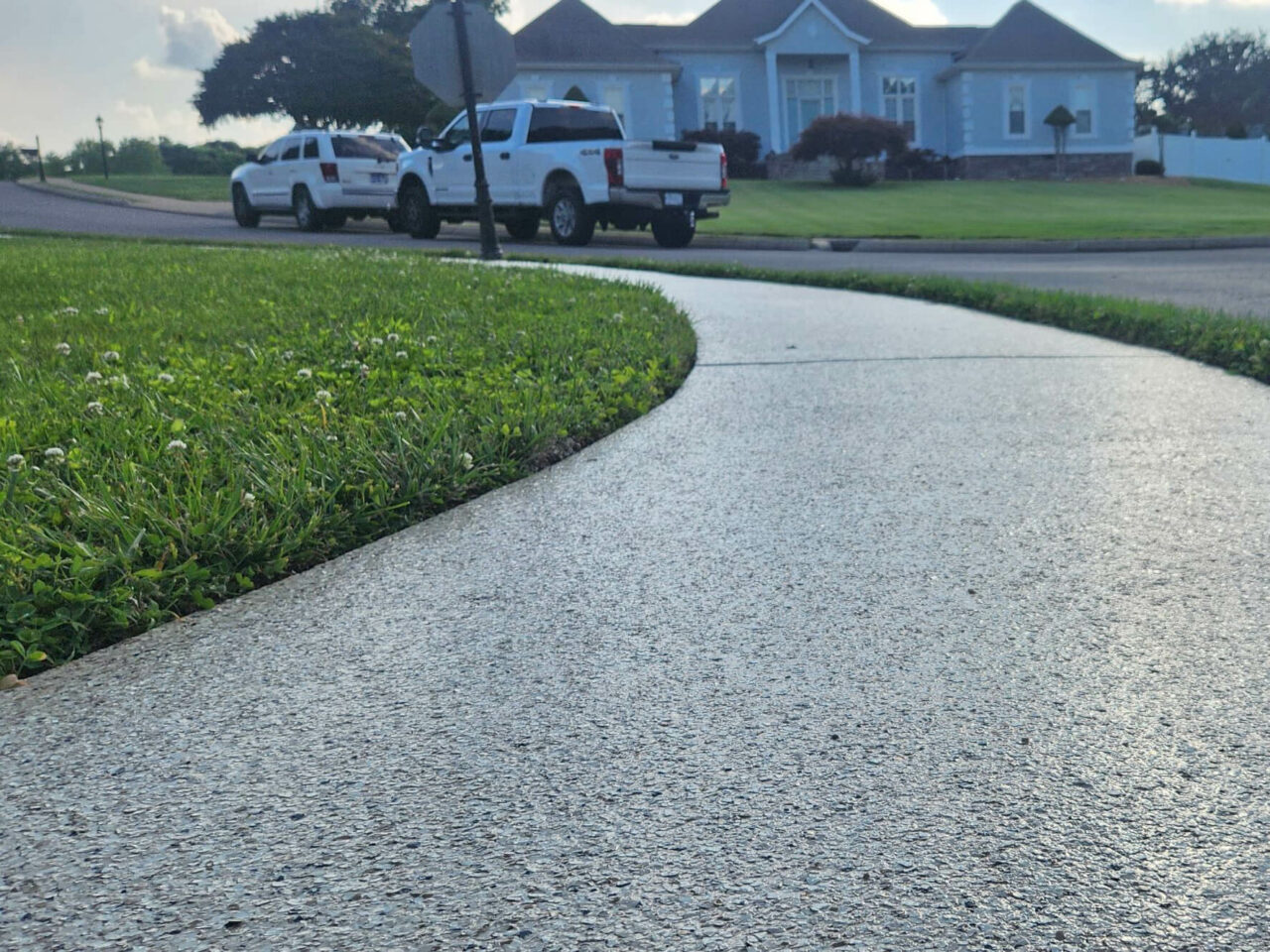 Curved residential sidewalk with textured epoxy coating providing slip resistance and a clean finish