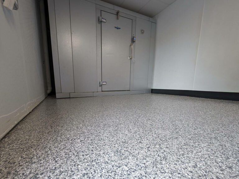 Commercial epoxy floor coating with gray flake finish in a clean industrial room