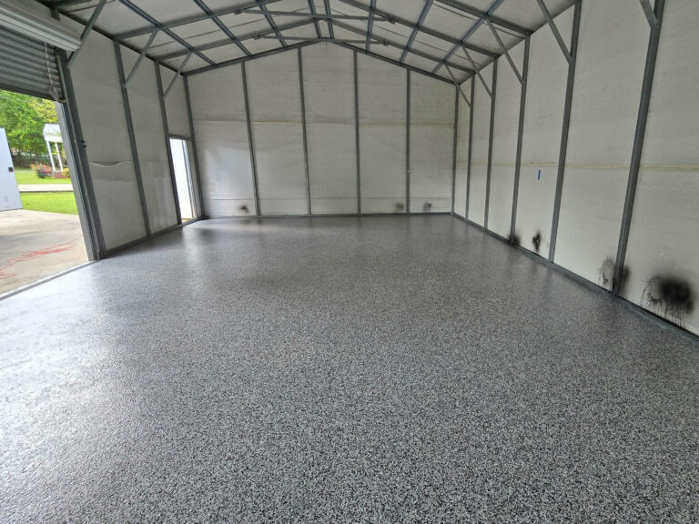 Spacious metal garage with freshly installed gray epoxy flake flooring providing a durable and easy-to-clean surface