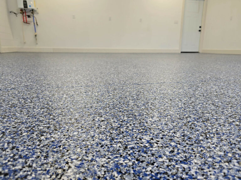 Blue and gray epoxy flake flooring in a clean residential garage, installed by Elite Floor Solutions