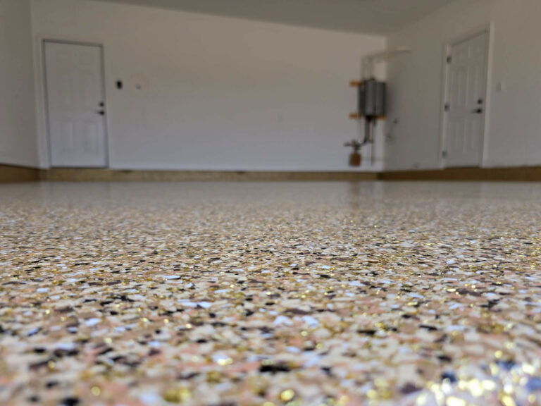 Tan and gold epoxy flake flooring in a residential garage, installed by Elite Floor Solutions