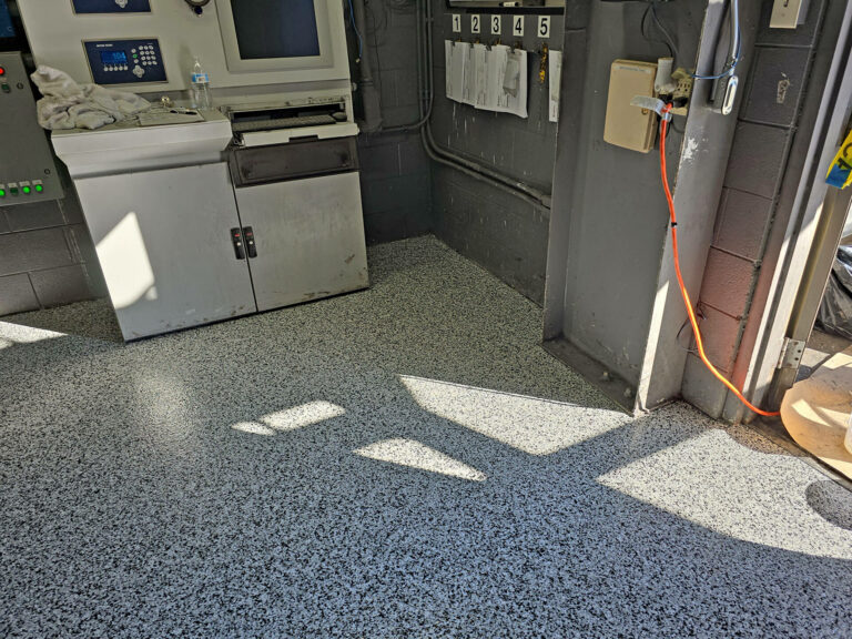 Epoxy flake floor coating in a commercial facility, gray speckled surface for durability and low-maintenance industrial flooring
