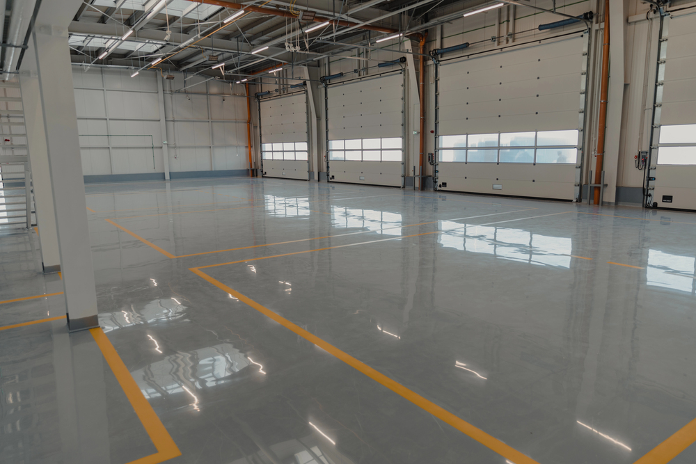 Large industrial warehouse with polished gray epoxy flooring and yellow safety lines
