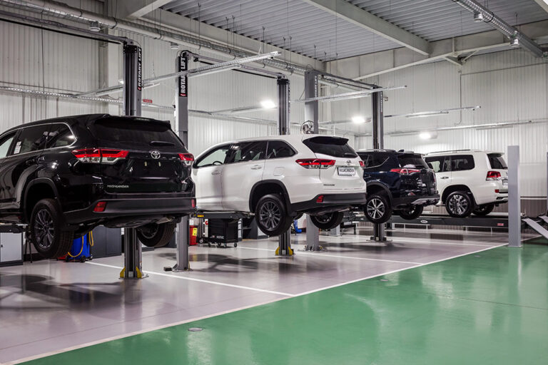 Automotive workshop with durable epoxy-coated floors in green and gray zones for high-traffic use