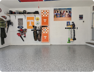 Gray epoxy flake garage floor in residential space with sports decor and organized wall storage